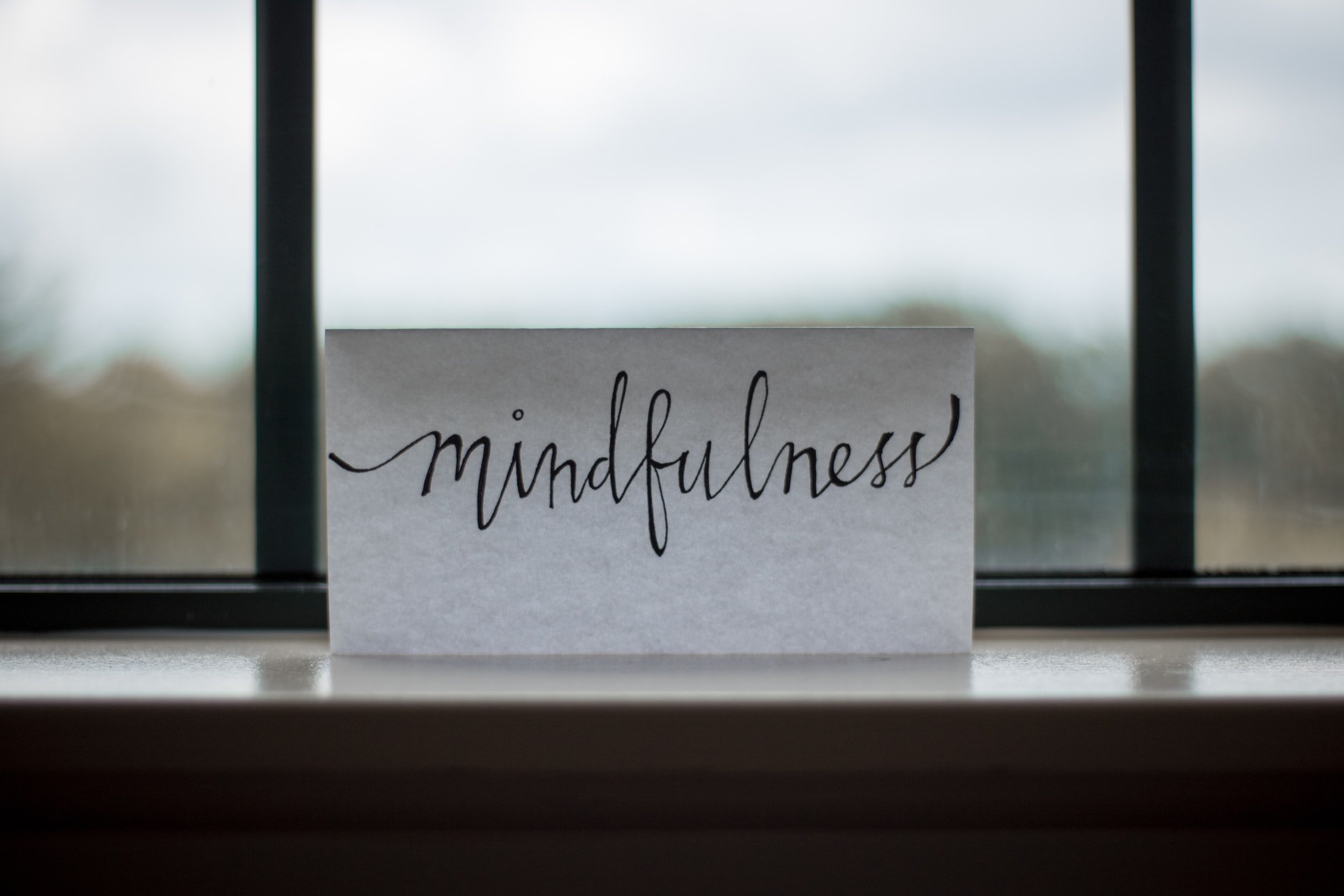 A small piece of paper with the word "mindfulness" in cursive.